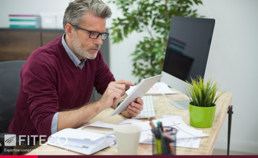 Dirigeant consultant une tablette pour gérer sa facturation électronique en entreprise.